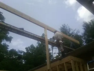 Carpenter setting a ridge beam over a new addition frame — Ice Dam Removal by Roofing Brothers in Kenvil