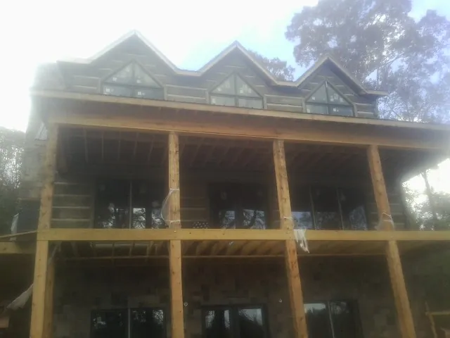Dormers and porch framing on a large log home under construction — Roof Coating work by our crew in Kenvil