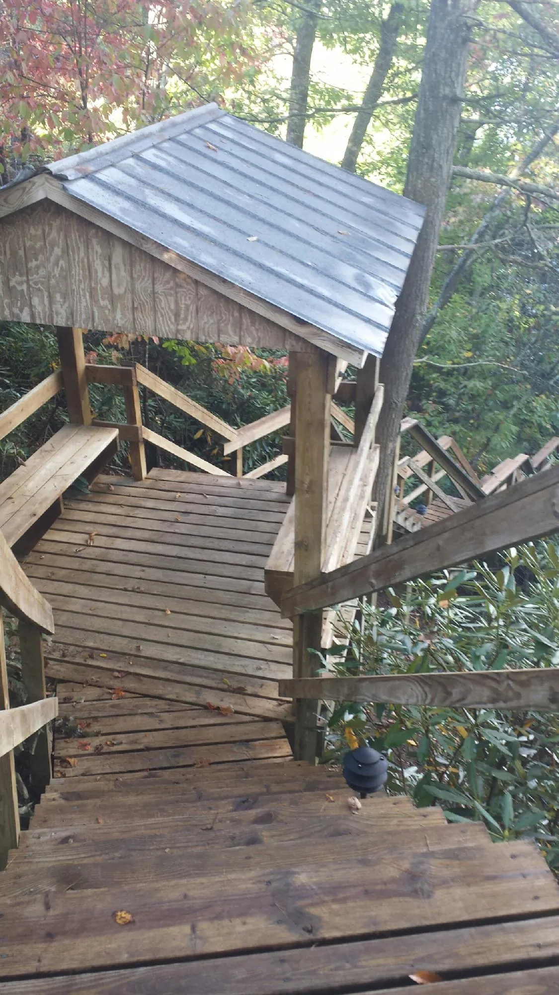 Metal roofed shelter over wooden steps on a wooded walkway — Skylight Repair & Installation work by our crew in Kenvil